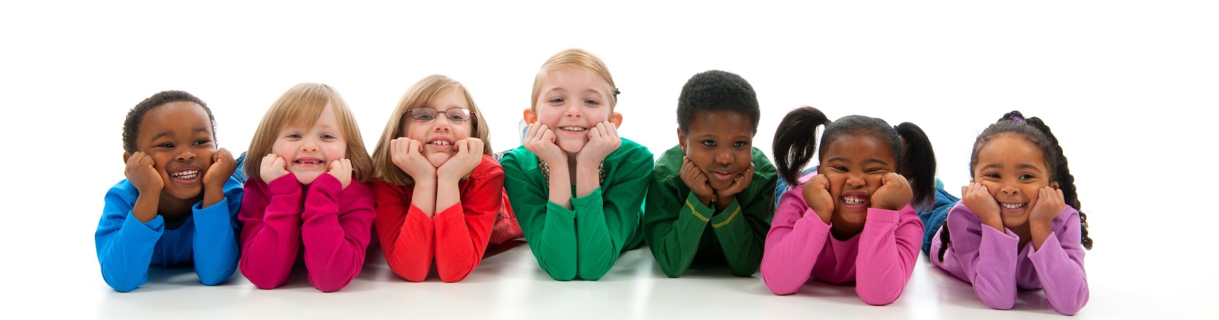 A group of smiling children lying side by side.